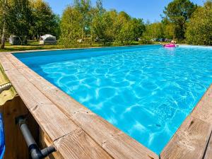a large swimming pool with blue water at Blue : La Roulotte du Médoc in Naujac-sur-Mer