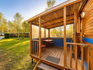 a wooden house with a table on a deck at Blue : La Roulotte du Médoc in Naujac-sur-Mer