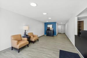 a waiting room with two chairs and a table and a tv at Suburban Studios Copley Akron West in Copley
