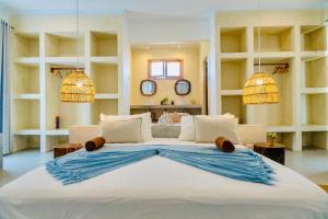 a large bed in a room with two mirrors at Mnana Beach Bungalows in Michamvi