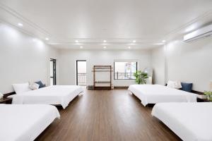 a white room with three beds in it at Palette Sunset Garden Tam Coc in Ninh Binh