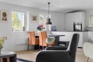 a kitchen and living room with a table and chairs at 1695-Hundested-Valdemar-Poulsensvej-11 in Lynæs +13 photos