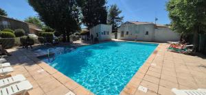 a swimming pool with blue water in a yard at maison de vacances in Tourrettes