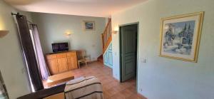 a living room with a staircase and a room with a television at maison de vacances in Tourrettes