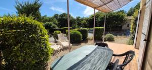 a patio with a table and chairs on a patio at maison de vacances in Tourrettes