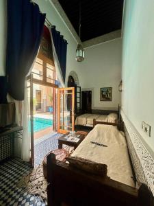 a bedroom with a bed and a swimming pool at Riad Fes Baraka Piscine & SPA in Fez