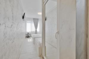a white bathroom with a shower and a sink at Neptune Breeze in Neptun