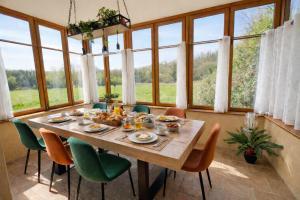a dining room with a table and chairs and windows at Quai du Val is a Charming Pet and Family Friendly Riverside Gite in Lehon close to Dinan Sleeps 7 in Dinan