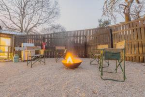 a fire pit in a backyard with chairs and a fence at The Explorers Camp in Renos
