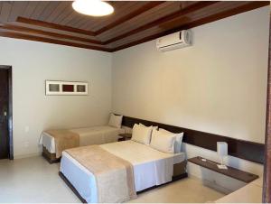 a hotel room with two beds and a heater at Hotel Gran Minas in Vespasiano