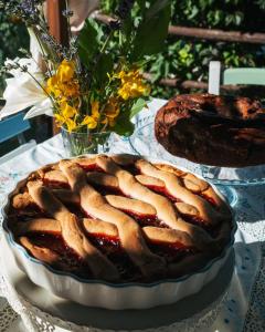 a cake on a plate on a table with flowers at B&B LE GRETTE in Gioia dei Marsi