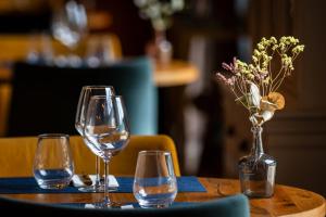 a table with three wine glasses and a vase with flowers at Hôtel des Augustins - Boutique Hôtel - Restaurant Gastronomique in Saint-Cyprien +60 photos