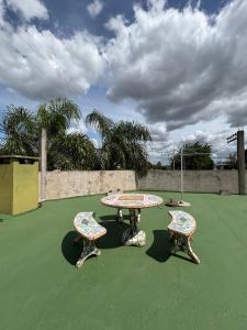 a table and two chairs sitting on a green court at El quincho in San Pedro
