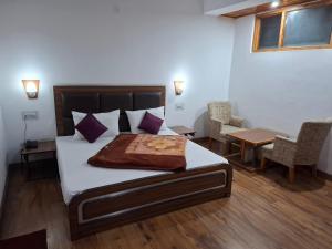 sypialnia z łóżkiem, stołem i krzesłami w obiekcie Hotel Moon In w mieście Kullu +37 zdjęć
