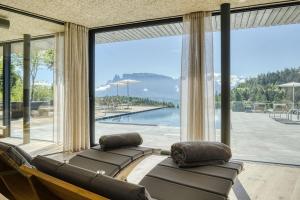 un soggiorno con un divano e una grande finestra di Hotel Lichtenstern a Soprabolzano