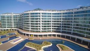 a large building with a pool in front of it at Maxihomes Snitch in Kemerağzı