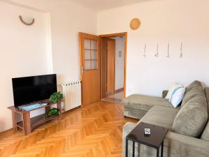 a living room with a couch and a flat screen tv at TIMO Apartment Split Croatia in Kaštela
