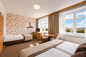 a hotel room with two beds and a desk at COLORFACTORY SPA Hotel - Czech Leading Hotels in Prague