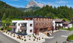 an aerial view of a building with a mountain in the background at Apartment Streif LXL in Kirchdorf in Tirol