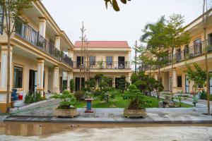 a courtyard with bonsai trees in front of a building at Palette Sunset Garden Tam Coc in Ninh Binh