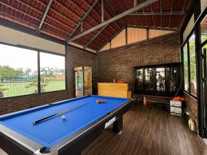 a pool table in a room with a brick wall at Palette Sunset Garden Tam Coc in Ninh Binh
