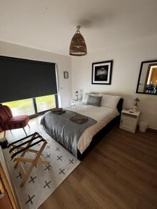 a bedroom with a bed and a large window at Achnacolain Lodge in Tarbert