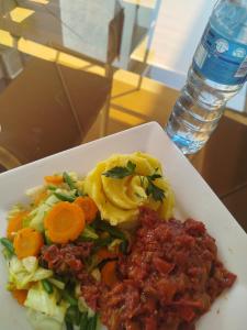 a white plate of food with vegetables and sauce at Valley in Kado