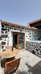 a patio with a wooden table and two chairs at Lagar de Elba in Las Manchas
