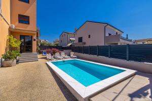 a swimming pool in the backyard of a house at Bellona in Malinska