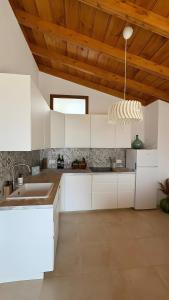a kitchen with white cabinets and a wooden ceiling at Lagar de Elba in Las Manchas