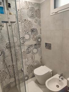 a bathroom with a shower and a toilet and a sink at AnnAmuri appartamento 23 in Belpasso