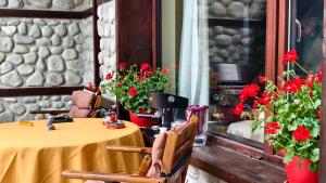 a table and chairs with red flowers in a room at Premium Villa Tode in Bansko
