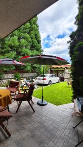 a patio with a table and chairs and an umbrella at Premium Villa Tode in Bansko