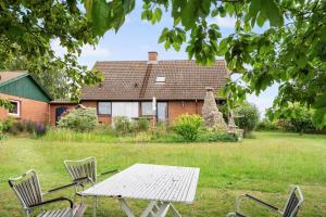 a picnic table and chairs in front of a house at 4044-Borre-Klintholm-Havnevej-40 in Borre