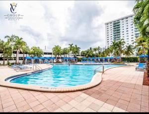 a pool at a resort with palm trees and a building at Ocean Reserve Miami Sunny Isles Collins Ave in Sunny Isles Beach