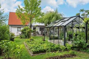 a greenhouse in a garden in front of a house at 6010-Askeby-Fanefjordgade-71 in Askeby