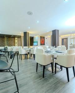 a dining room with white tables and chairs at Atlantis Hotel Lagos in Lagos