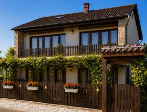 a house with a fence and flower pots on it at Sefira Homes Y in Keszthely