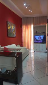 a living room with a couch and a flat screen tv at Apartamento in Montes Claros