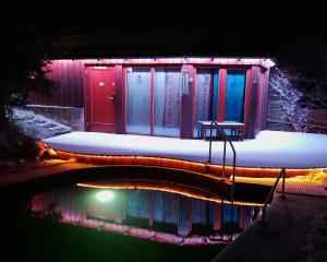 a house with a reflection in the water at night at Guest House Sněžník in Sněžnik