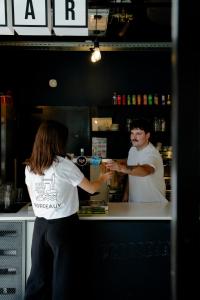 a man and a woman standing behind a counter at SLO HOSTEL Bordeaux in Bordeaux +80 photos
