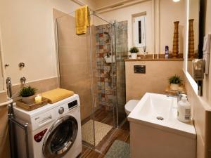 a bathroom with a washing machine and a sink at Sefira Homes Y in Keszthely