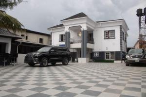 a black car parked in front of a white house at Star Haven Hotel and suites in Badore