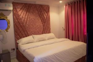 a bedroom with a bed with a large headboard at Star Haven Hotel and suites in Badore +2 photos