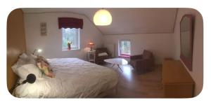 a bedroom with a white bed and a living room at chambre dans les bois in Namur