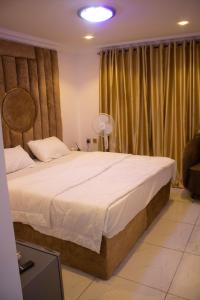 a bedroom with a large white bed with curtains at Star Haven Hotel and suites in Badore