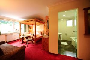 a living room with a bed and a room with a bathroom at Alpenhof Pitztal in Sankt Leonhard im Pitztal +27 photos