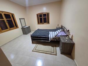 a bedroom with a bed with a black and white blanket at la Citronnelle in Oualidia