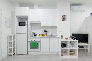 a white kitchen with a stove and a microwave at Studio New Complete 4 pax in Madrid