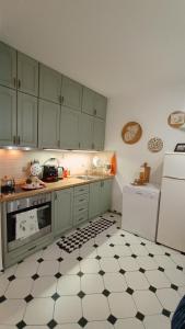a kitchen with green cabinets and a black and white floor at къща Утринна Роса in Blŭskovtsi +20 photos